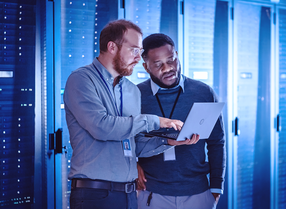 Two men in data center looking at a laptop